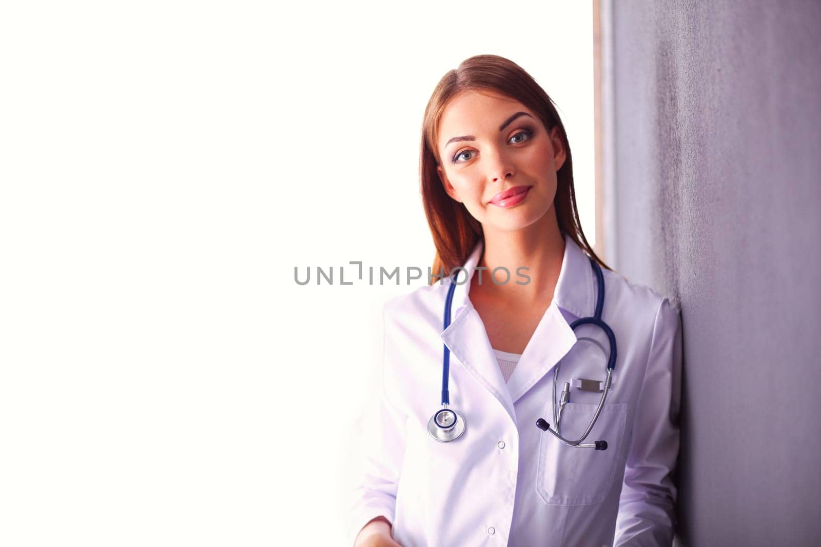 Portrait of female doctor standing against isolated on white background. Woman doctor