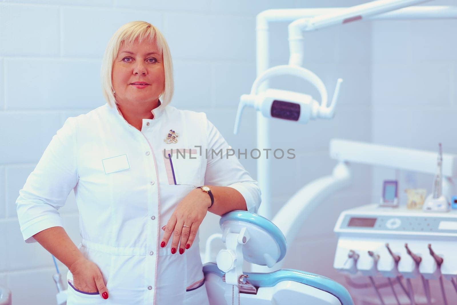 Woman dentist standing in her office smiling.