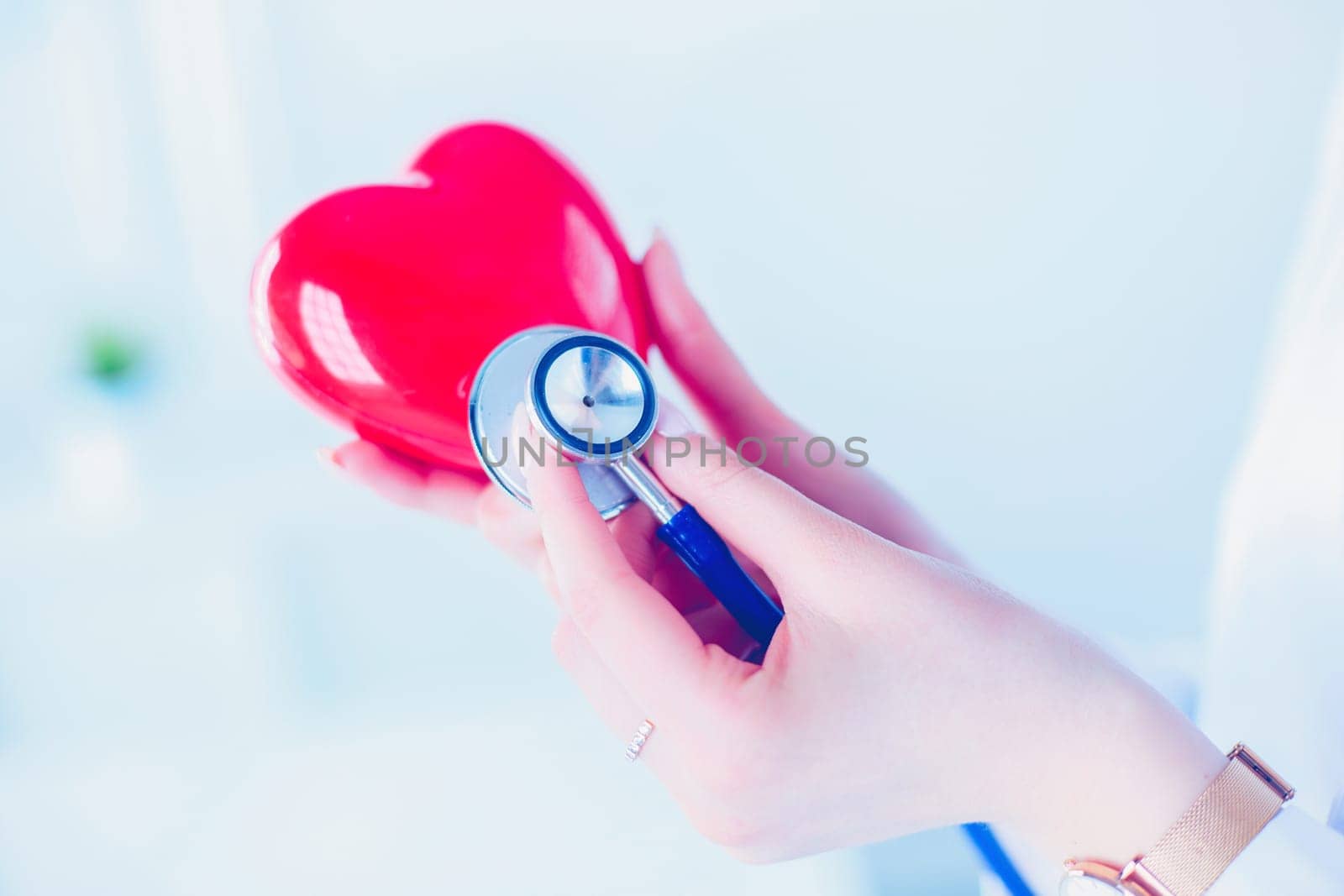 A doctor with stethoscope examining red heart, isolated on white background.