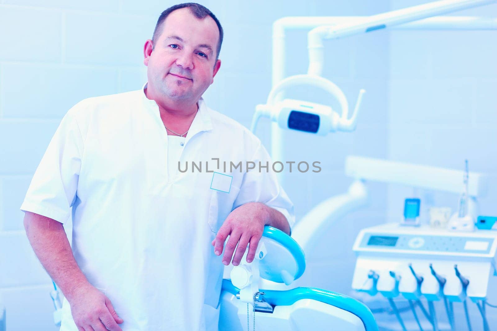 Portrait of a smiling dentist standing in dental clinic.