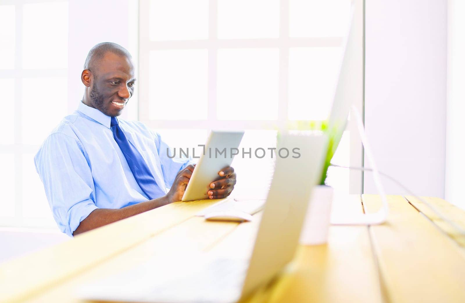 African american businessman on headset working on his laptop.