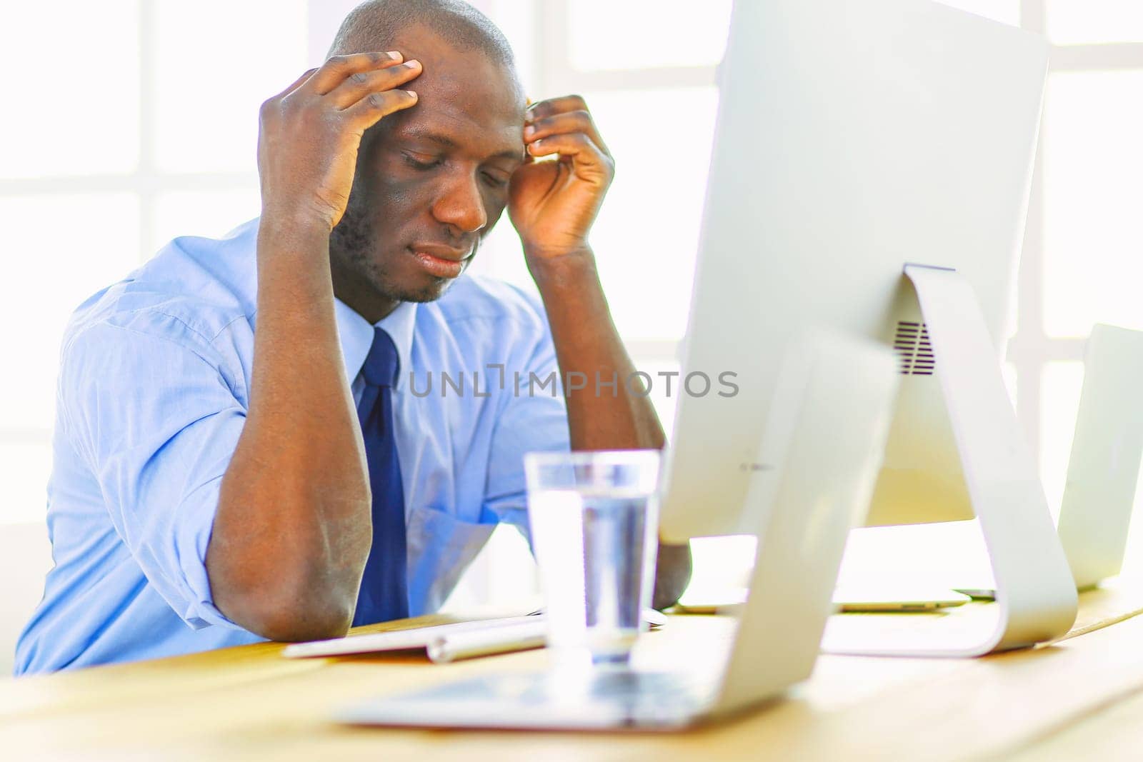 African american businessman on headset working on his laptop.