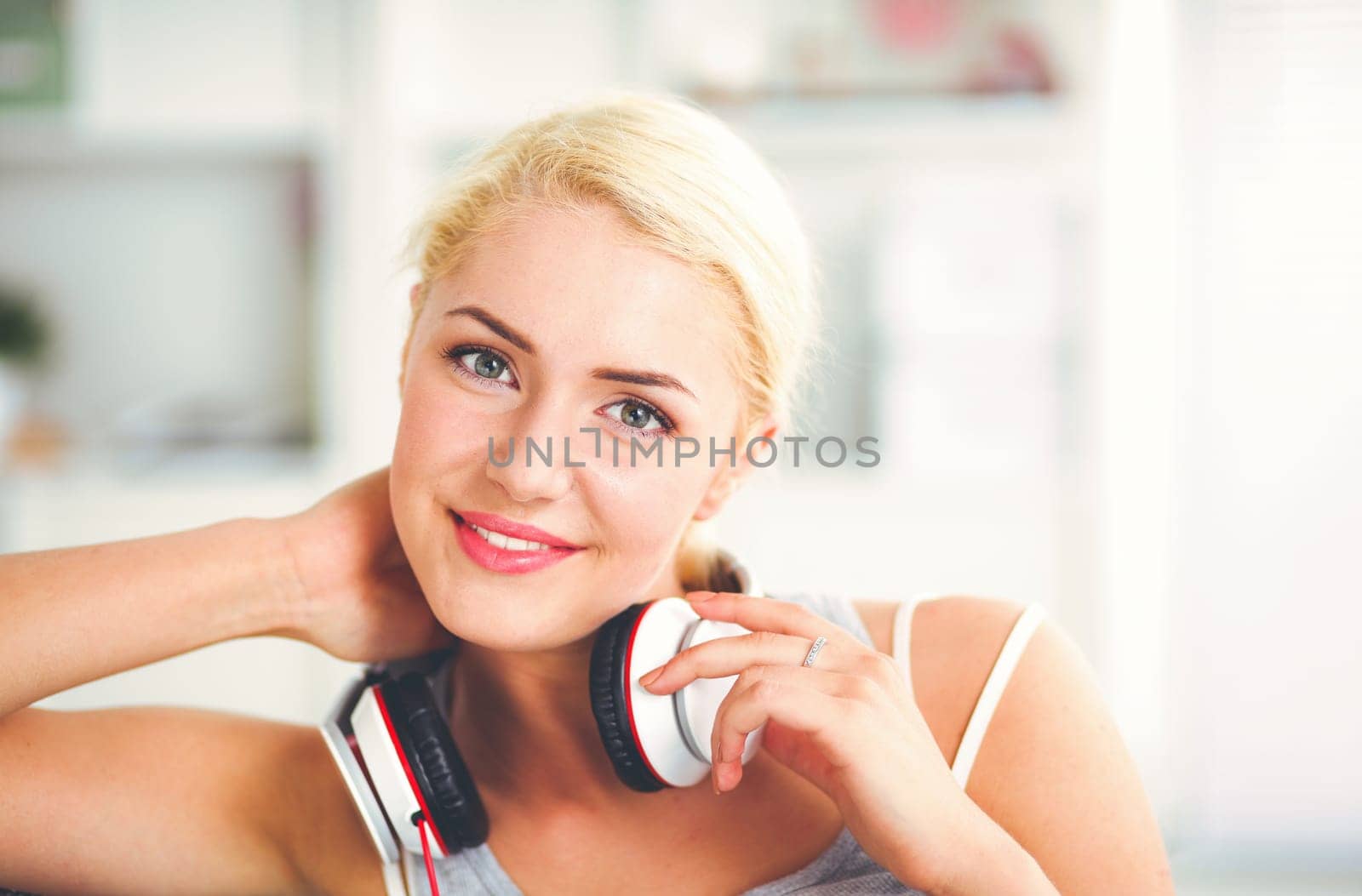 Young beautiful woman at home sitting on sofa and listening music.