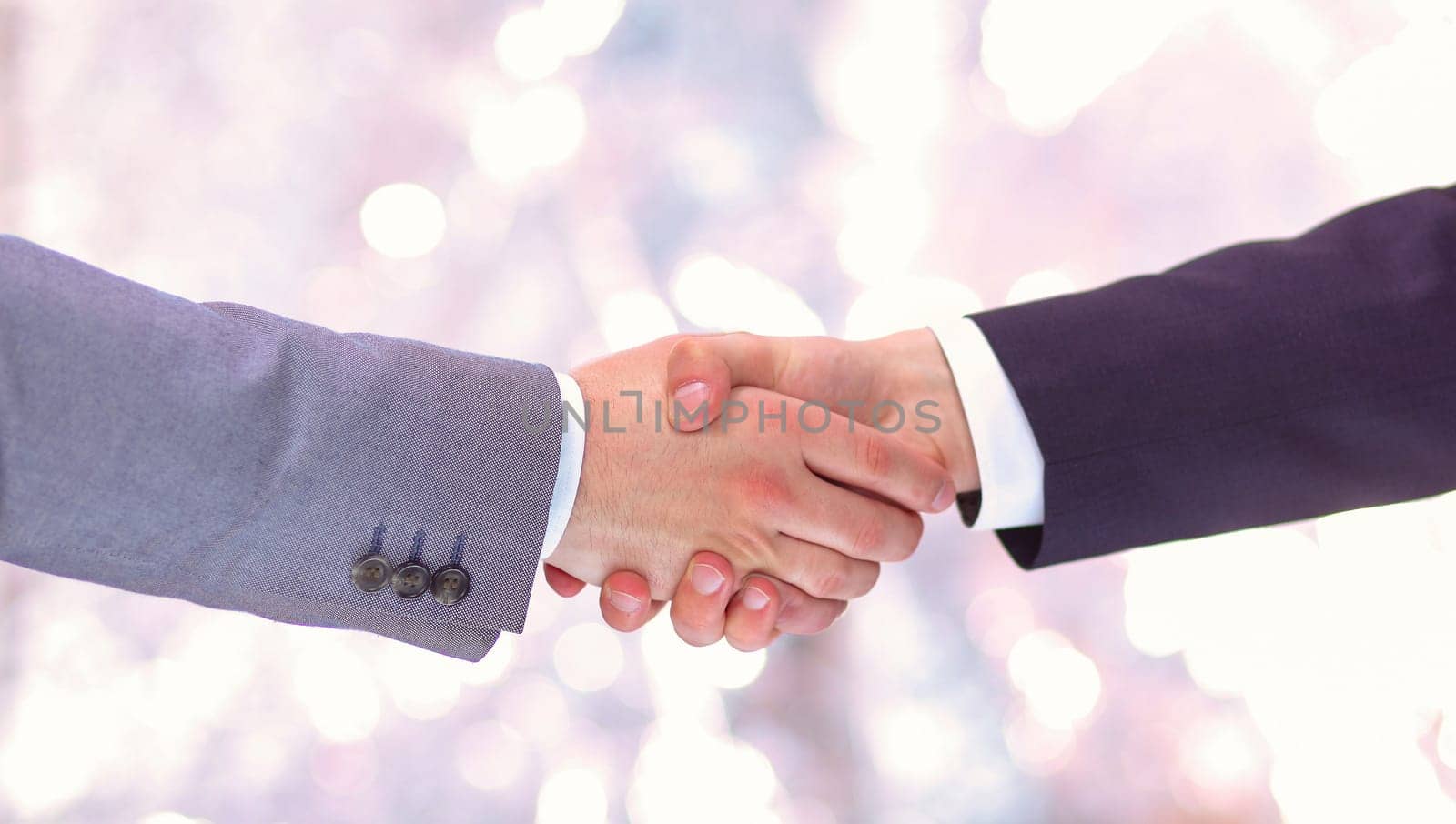 Clouse-up of businessman and businesswoman shaking hands.