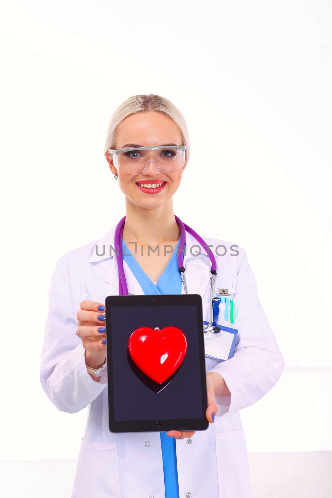 Young woman doctor holding a red heart, isolated on white background. Woman doctor.