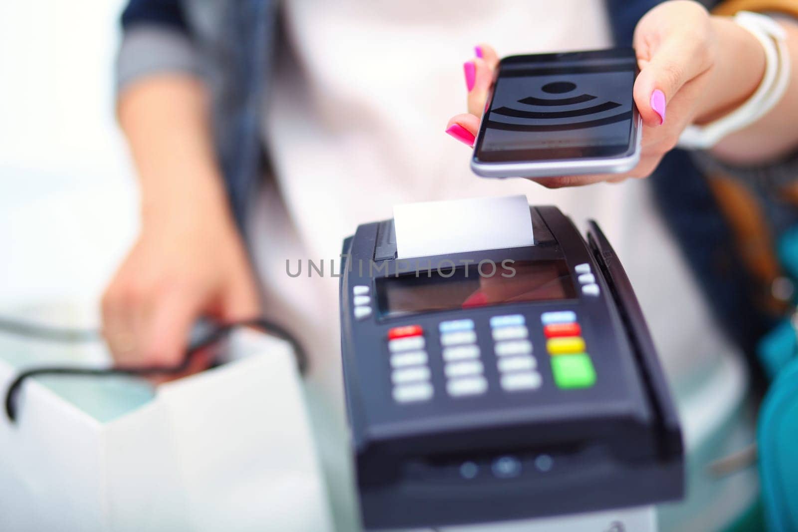 Customer is paying with smartphone in shop using NFC technology. NFC technology. Customer is paying.