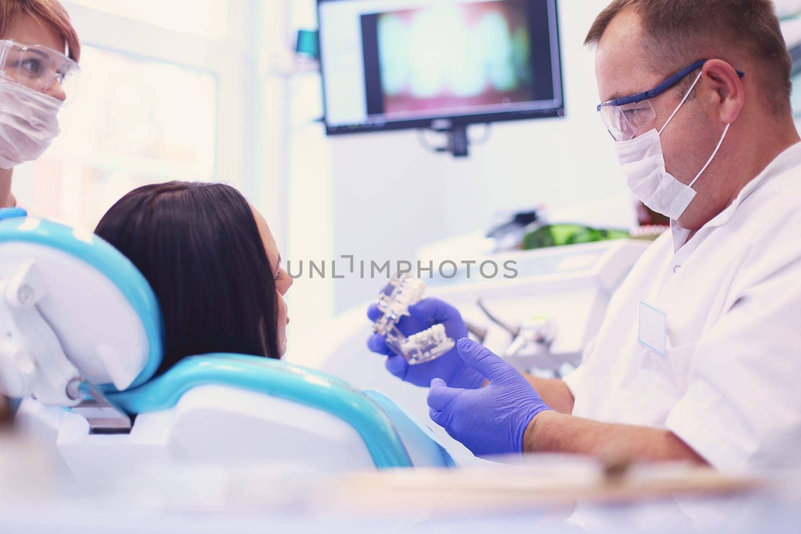 Beautiful senior woman at dentist having dental treatment at dentist's office.