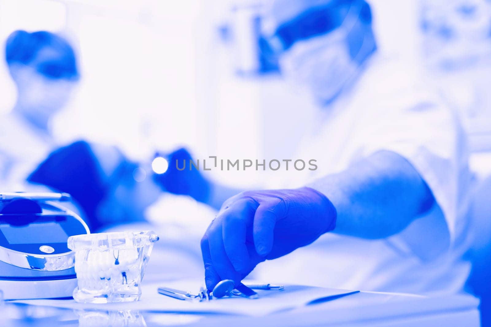 Senior male dentist adjust searchlight before starting work.