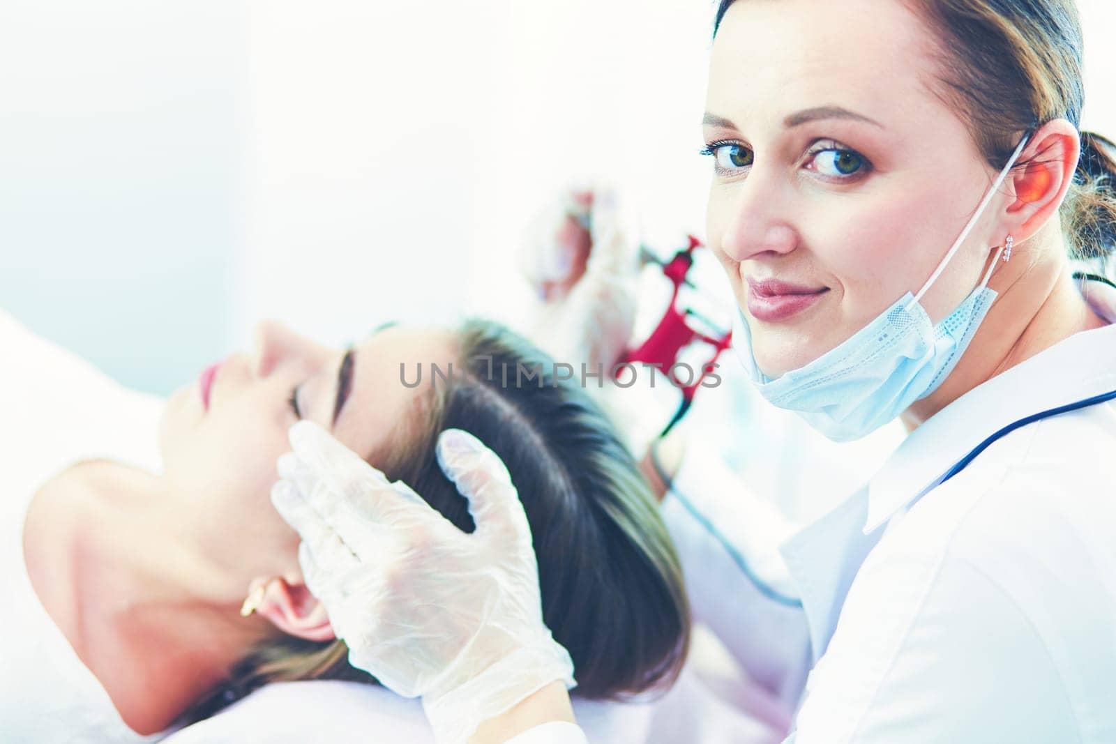 A young girl having red lips permanent makeup, micropigmentation.