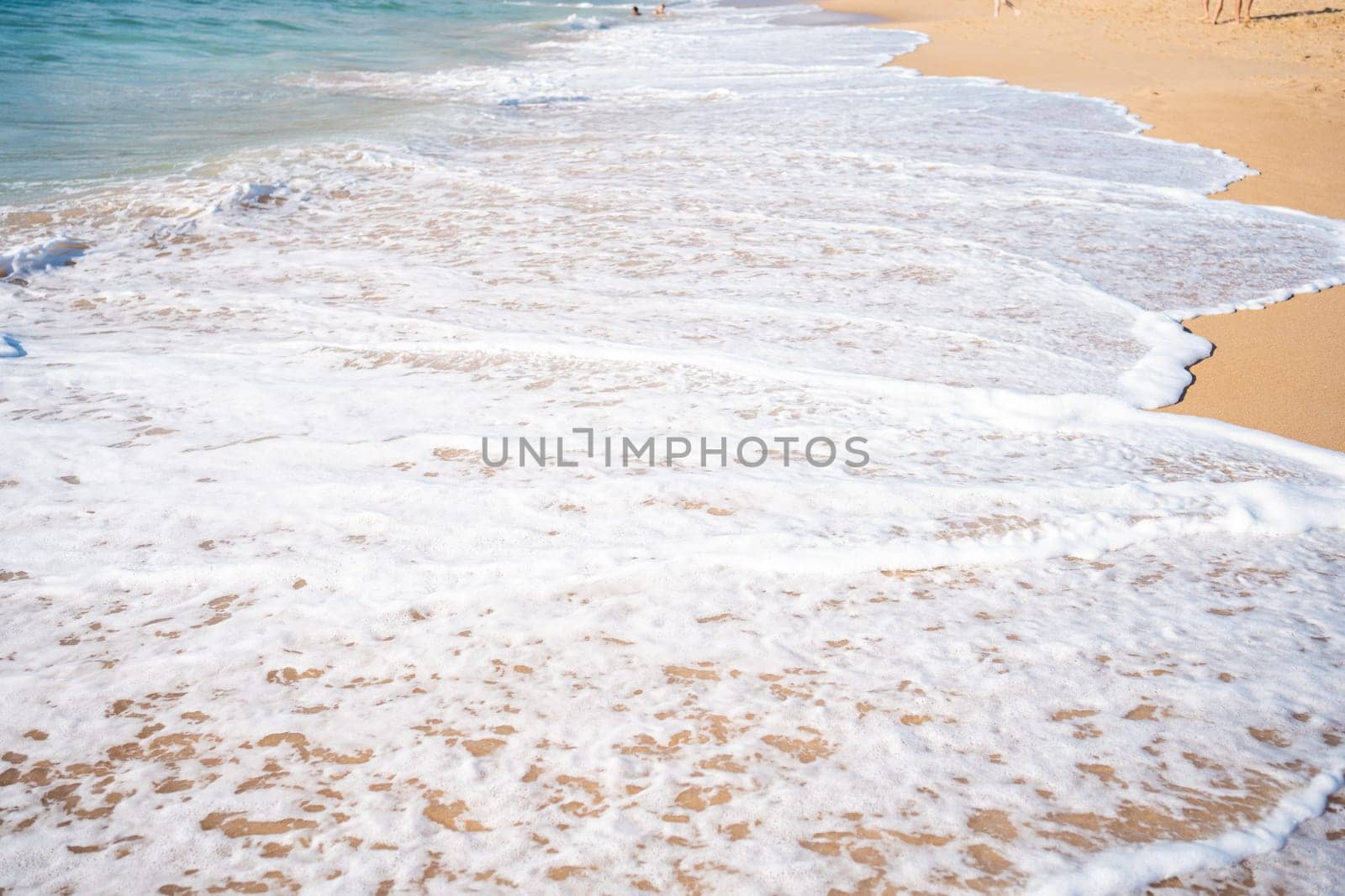 Soft beautiful ocean wave on sandy beach. Background. Turquoise color sea view with copy space