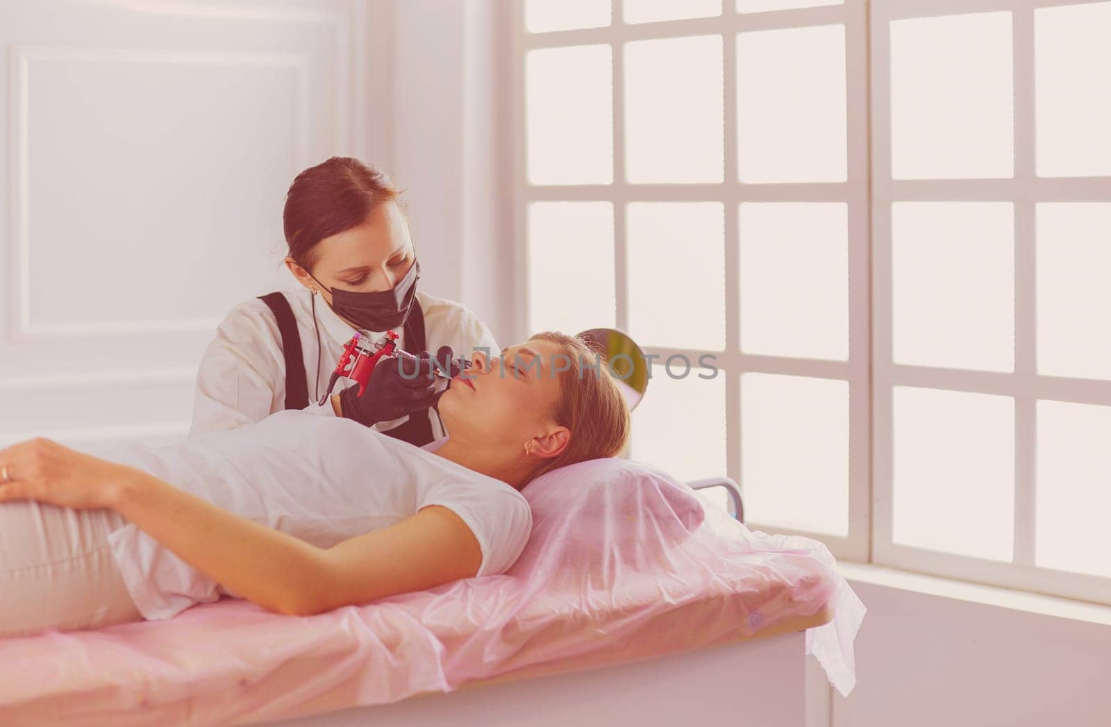 Cosmetologist applying permanent make up on eyebrows.