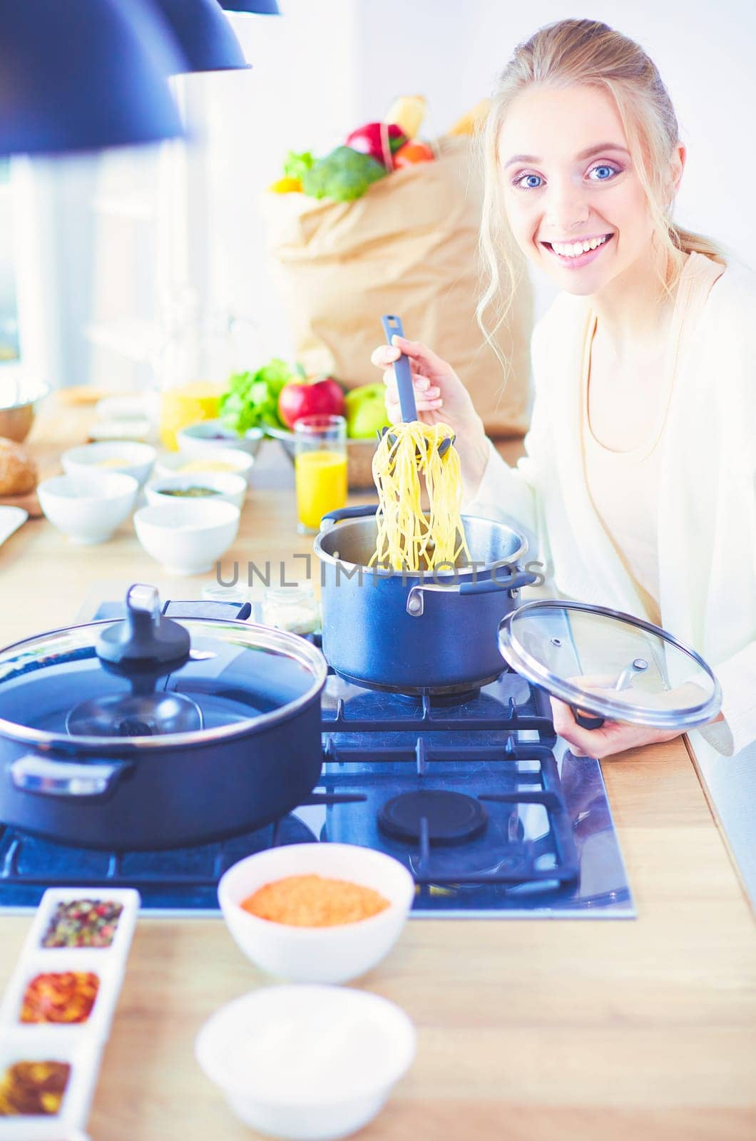 Beautiful young woman cooking in kitchen at home.