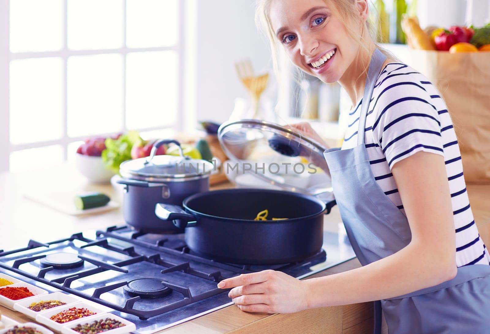 Beautiful young woman cooking in kitchen at home.