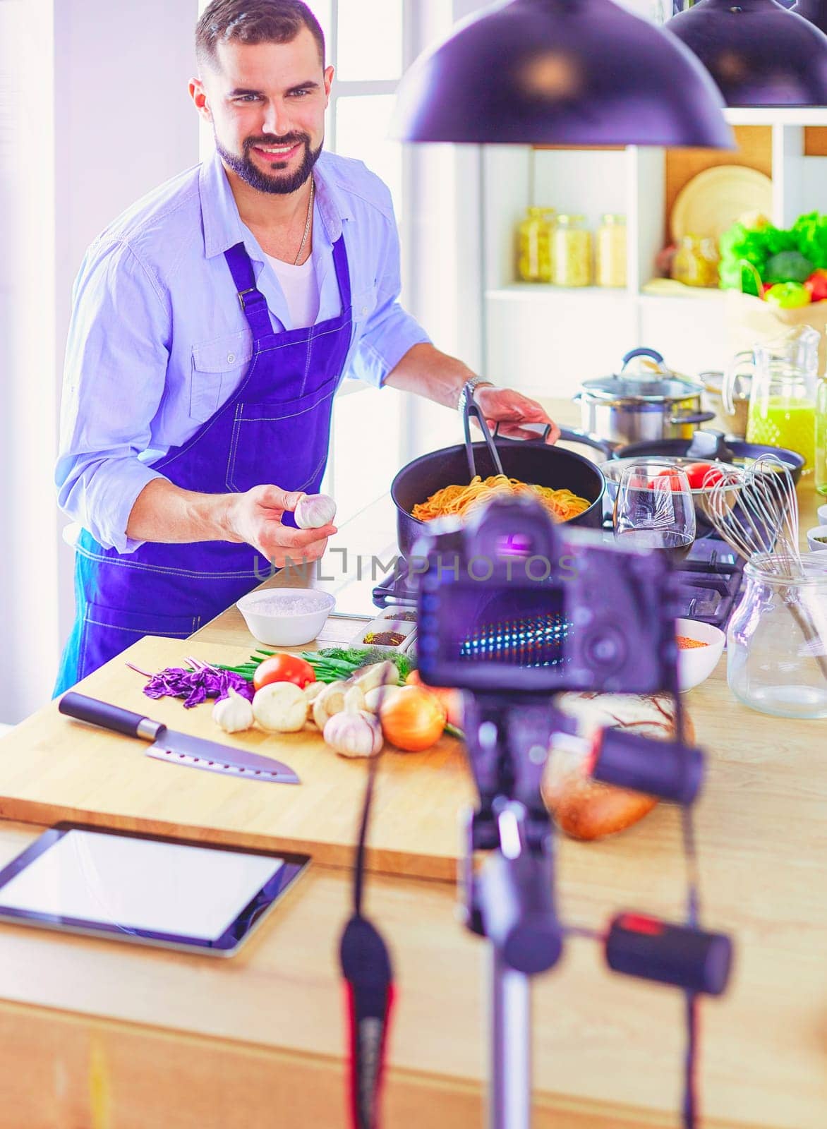 Man holding paper bag full of groceries on the kitchen background. Shopping and healthy food concept.