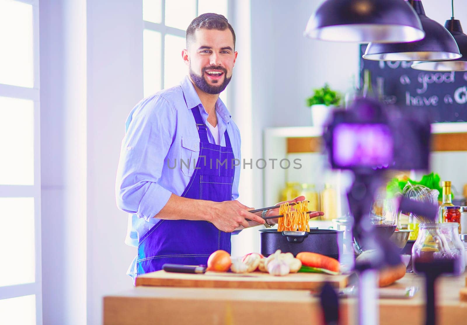 Man holding paper bag full of groceries on the kitchen background. Shopping and healthy food concept.