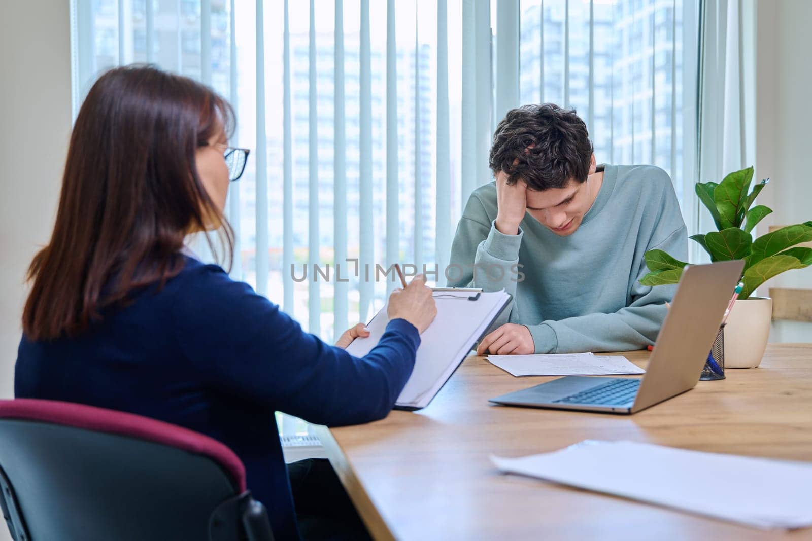 School psychologist, social worker supporting guy student, sitting in office of educational building. Mental health of youth, psychology, psychotherapy, therapy, professional help support