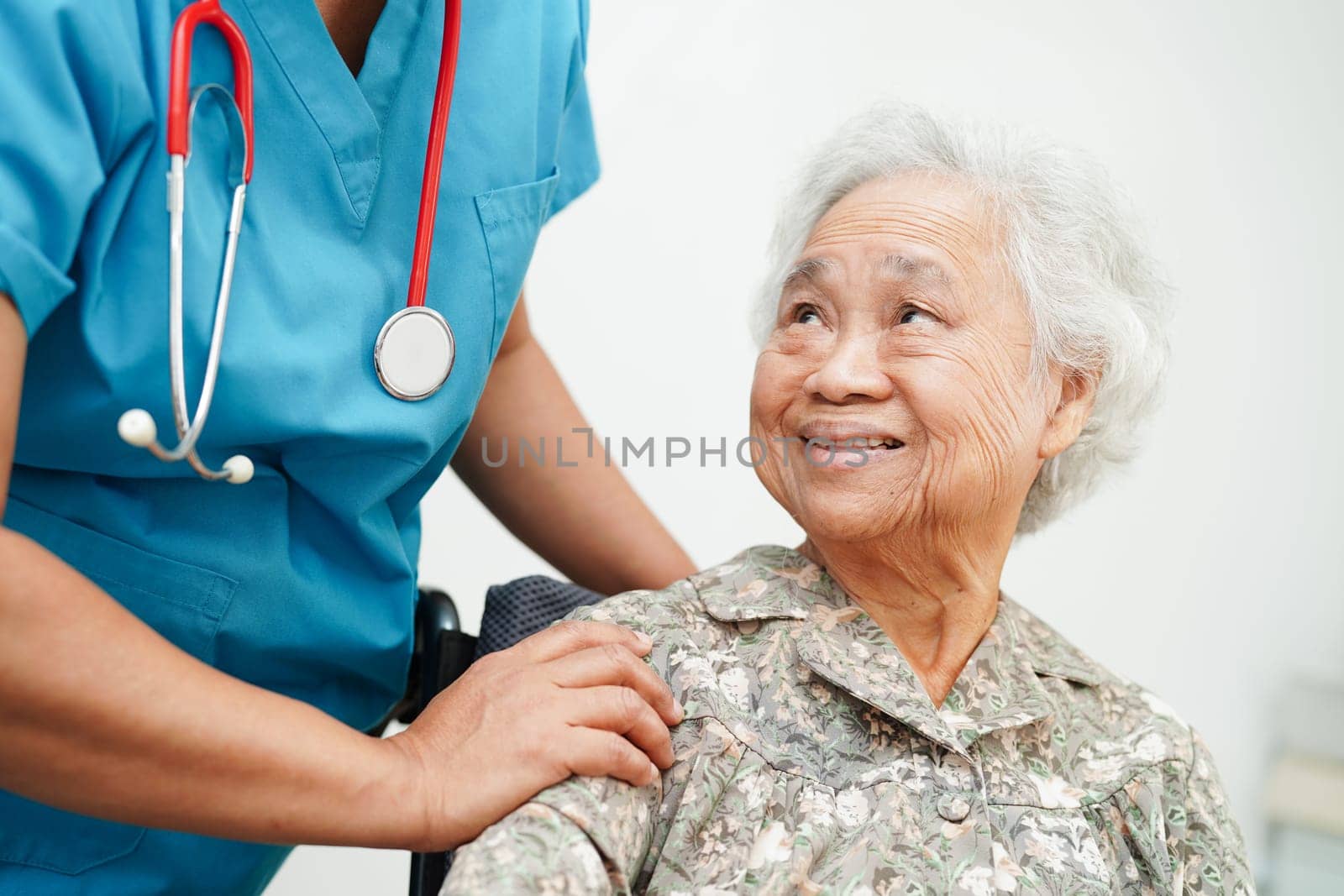 Doctor help Asian elderly woman disability patient sitting on wheelchair in hospital, medical concept.