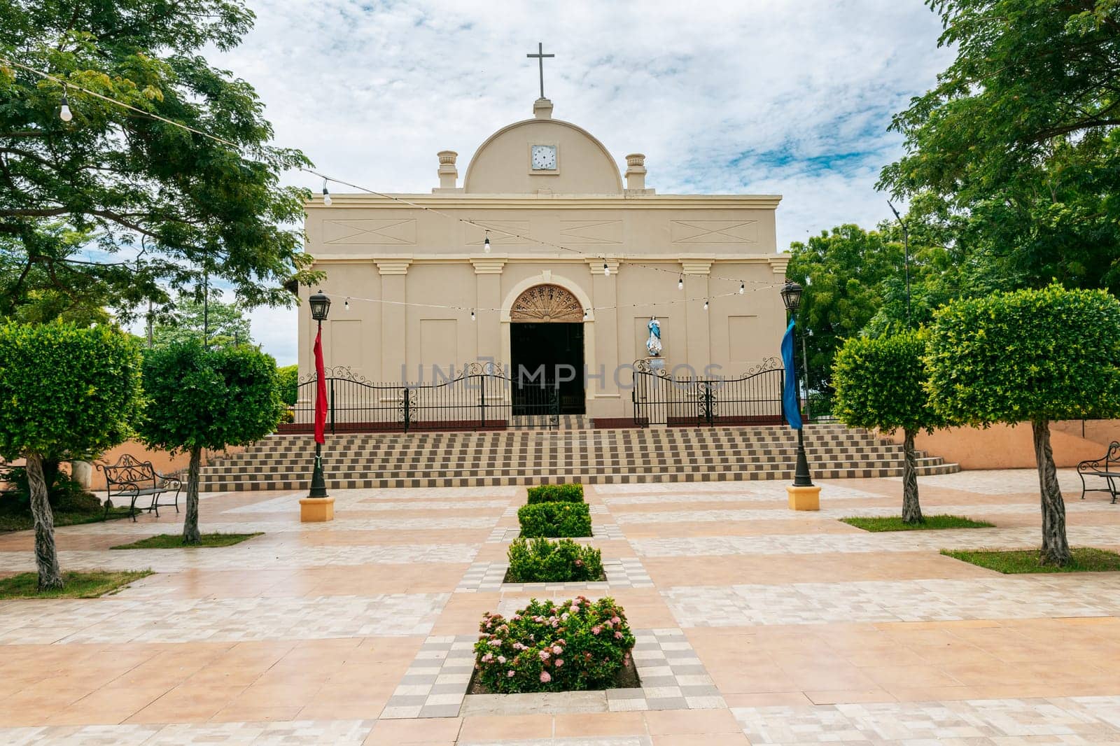 Beautiful church in a park with a garden and trees. Nagarote Park Catholic Church. Nicaragua, View of a church in a beautiful central park on a sunny day.