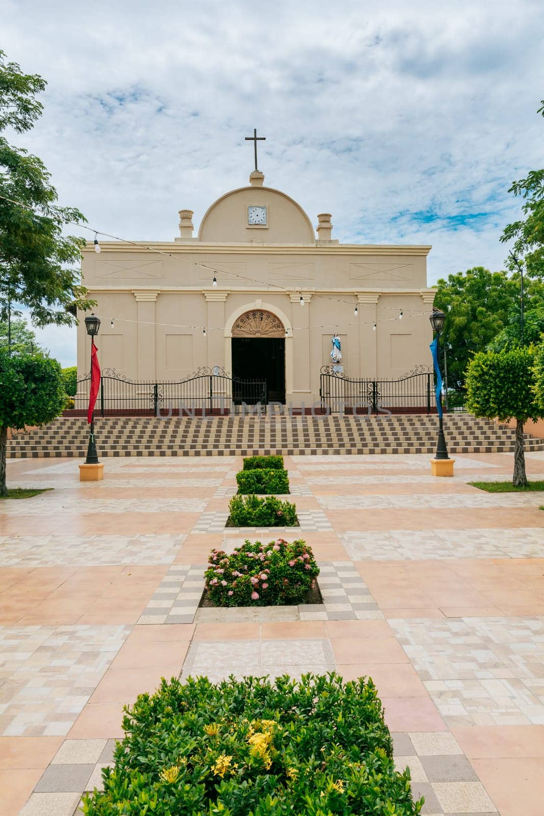 Nagarote Park Catholic Church. Nicaragua, View of a church in a beautiful central park on a sunny day. Beautiful church in a park with a garden and trees by isaiphoto