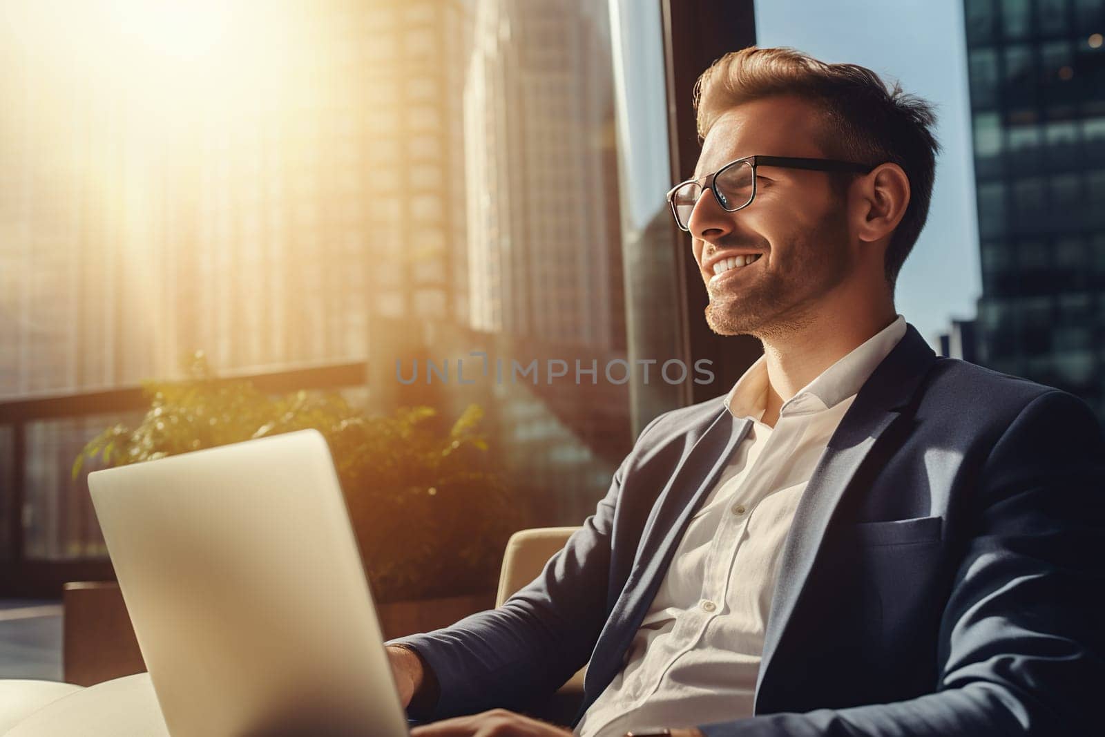 Young man working in office on a laptop at sunset