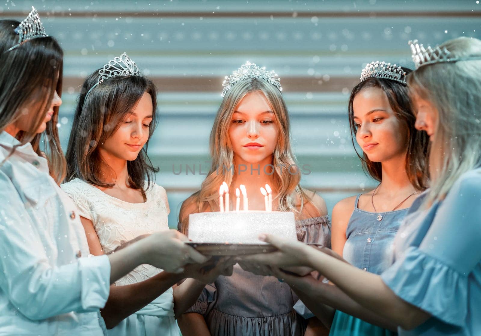 Cute birthday girl and friends holding cake with candles