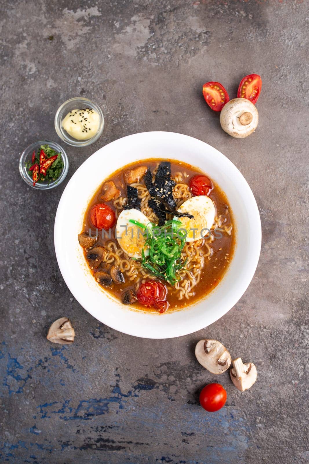 spicy traditional ramen with egg, mushrooms and seafood top view.