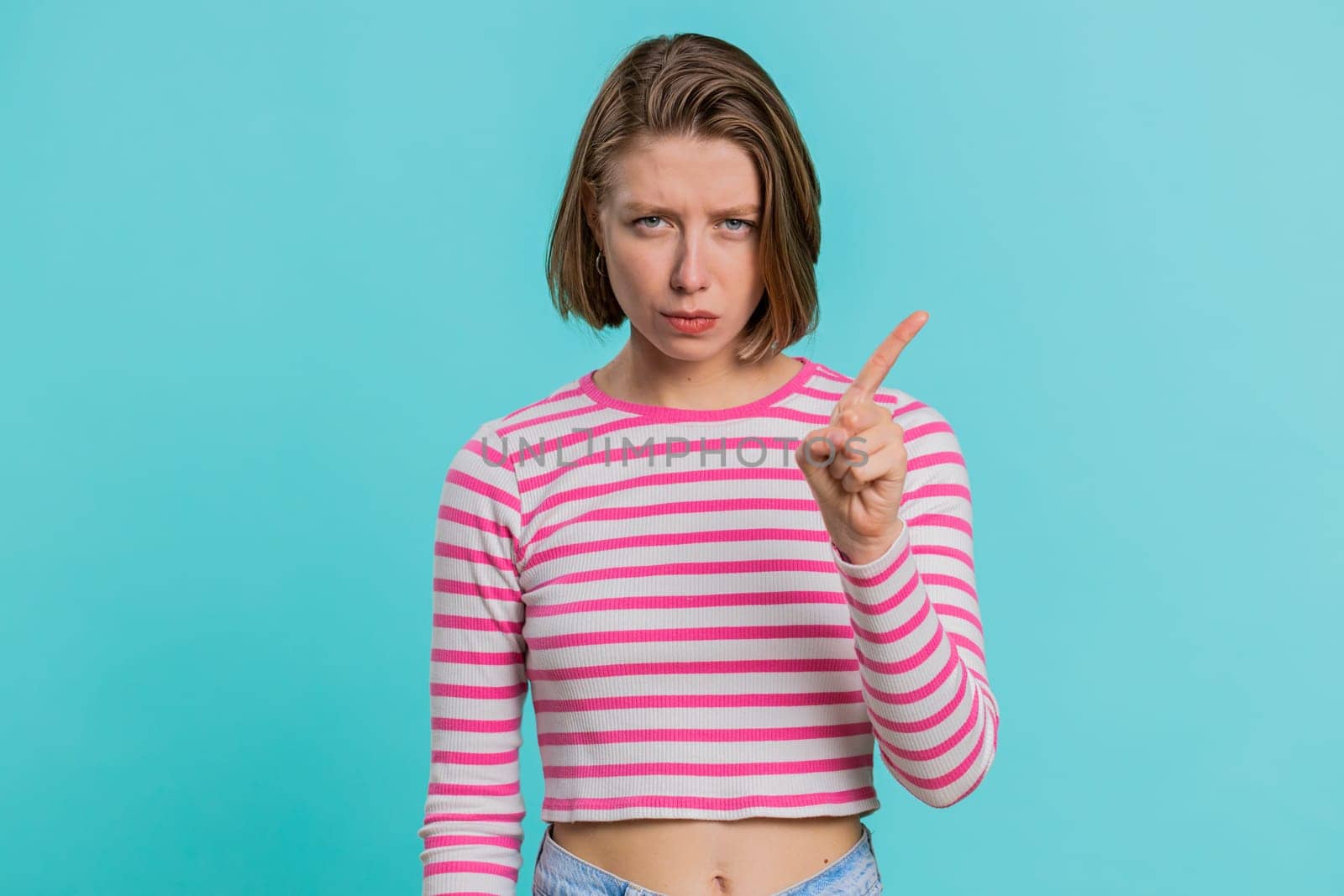 Displeased upset Caucasian woman reacting to unpleasant awful idea, dissatisfied with bad quality, wave hand, shake head No, dismiss idea, dont like proposal. Girl isolated on blue studio background
