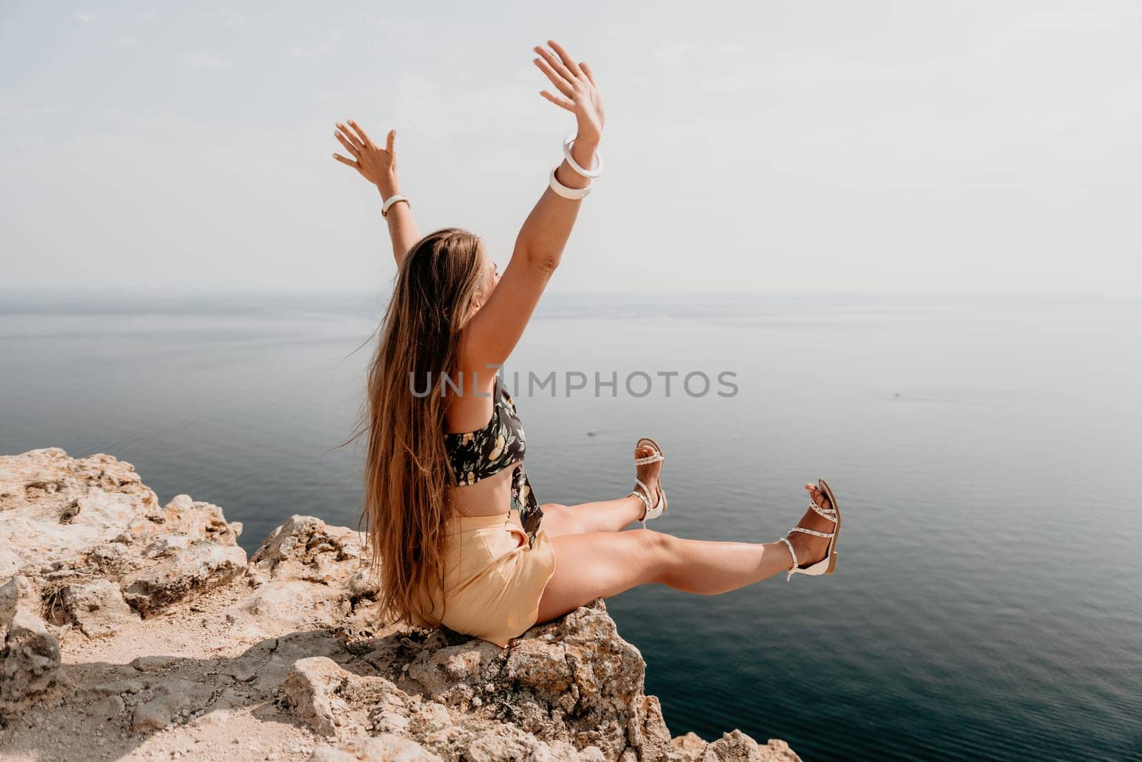 Woman travel sea. Happy tourist enjoy taking picture outdoors for memories. Woman traveler looks at the edge of the cliff on the sea bay of mountains, sharing travel adventure journey by panophotograph