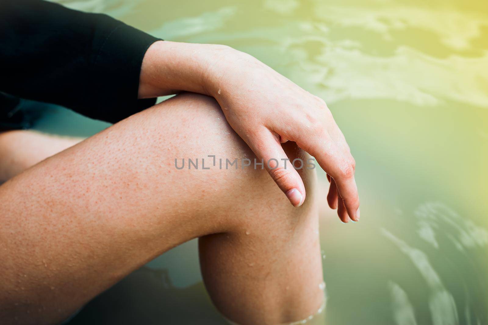 female hand and foot on a background of water