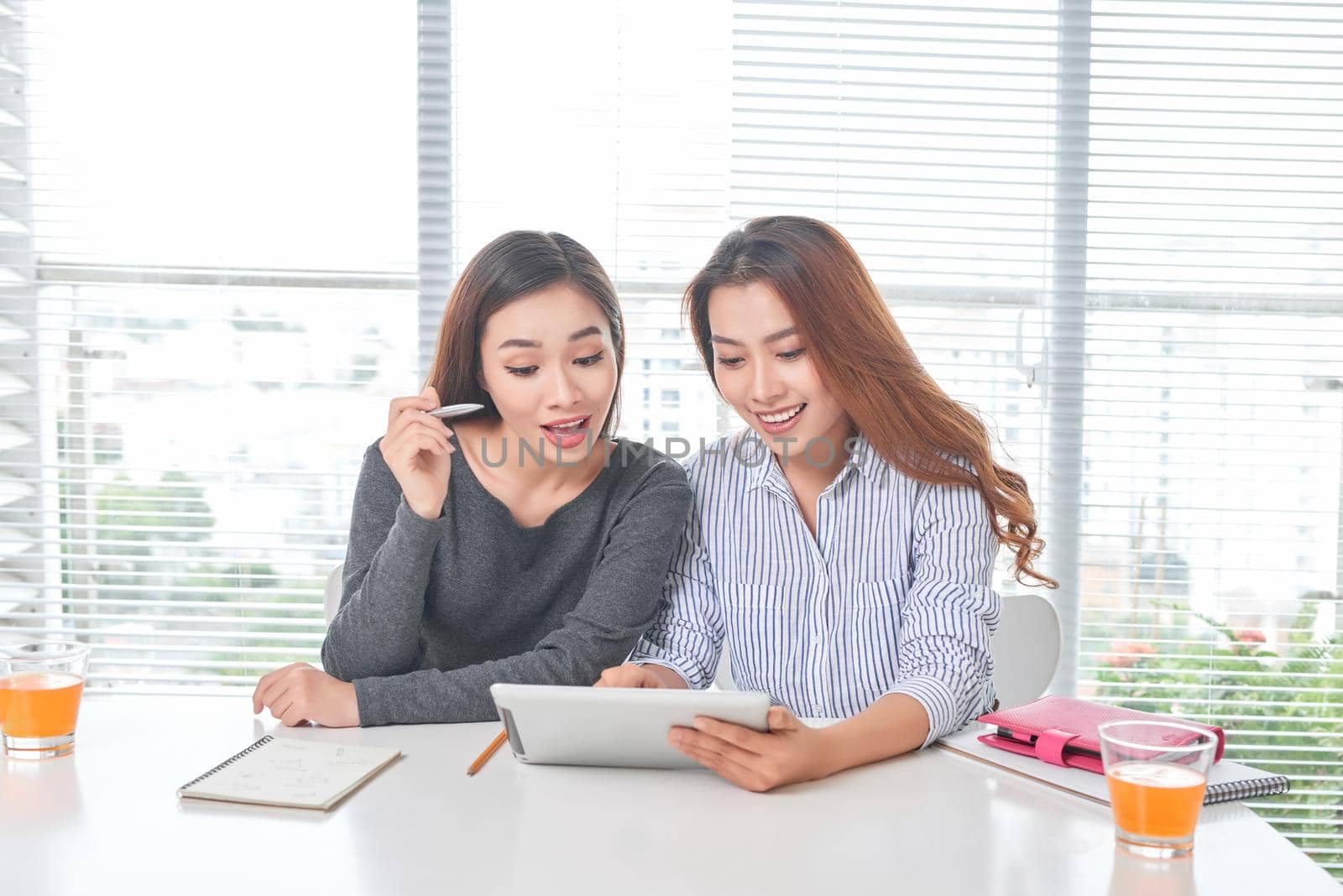 Happy young businesswoman talking to her colleague