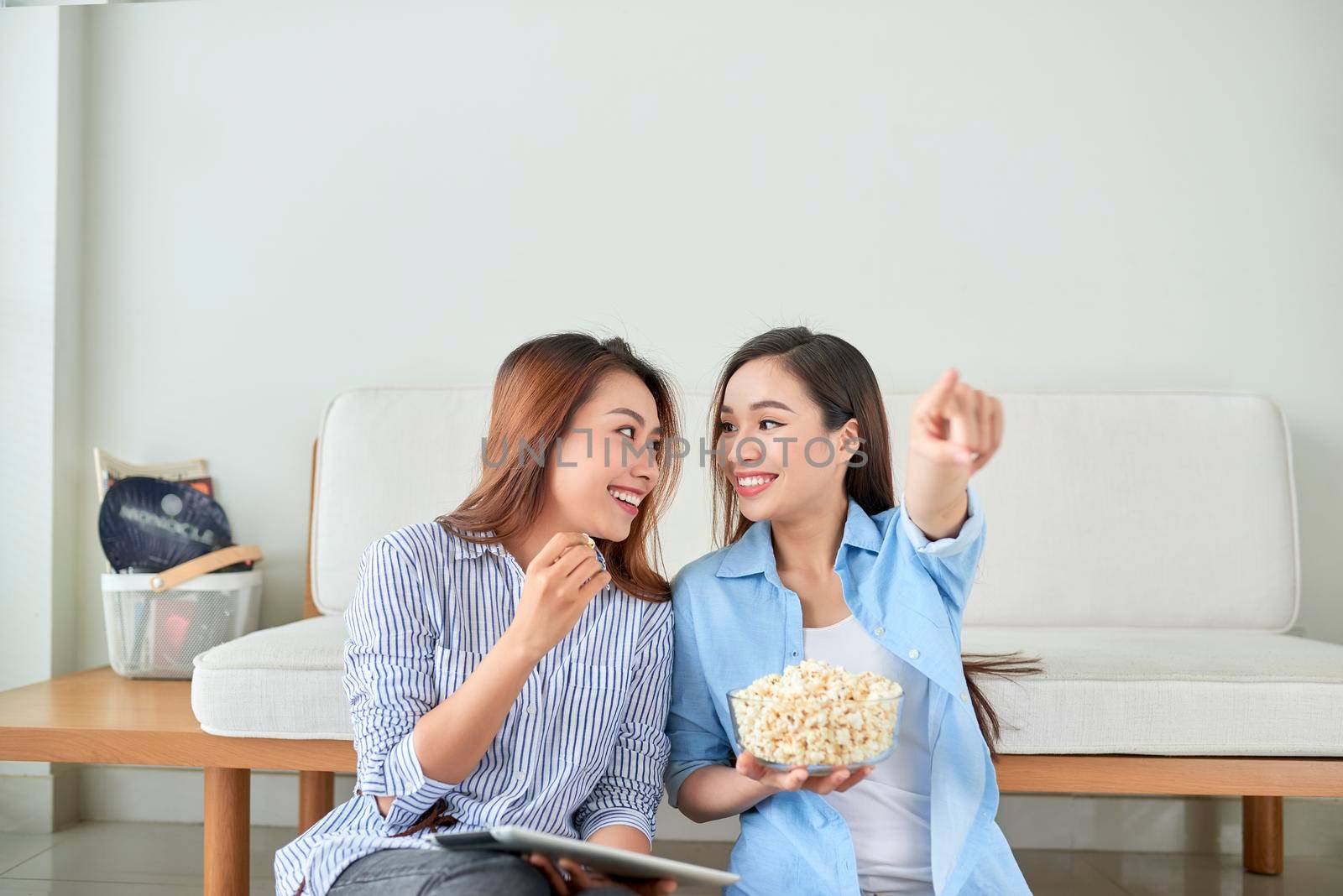 Happy girl friend watching tv at home.