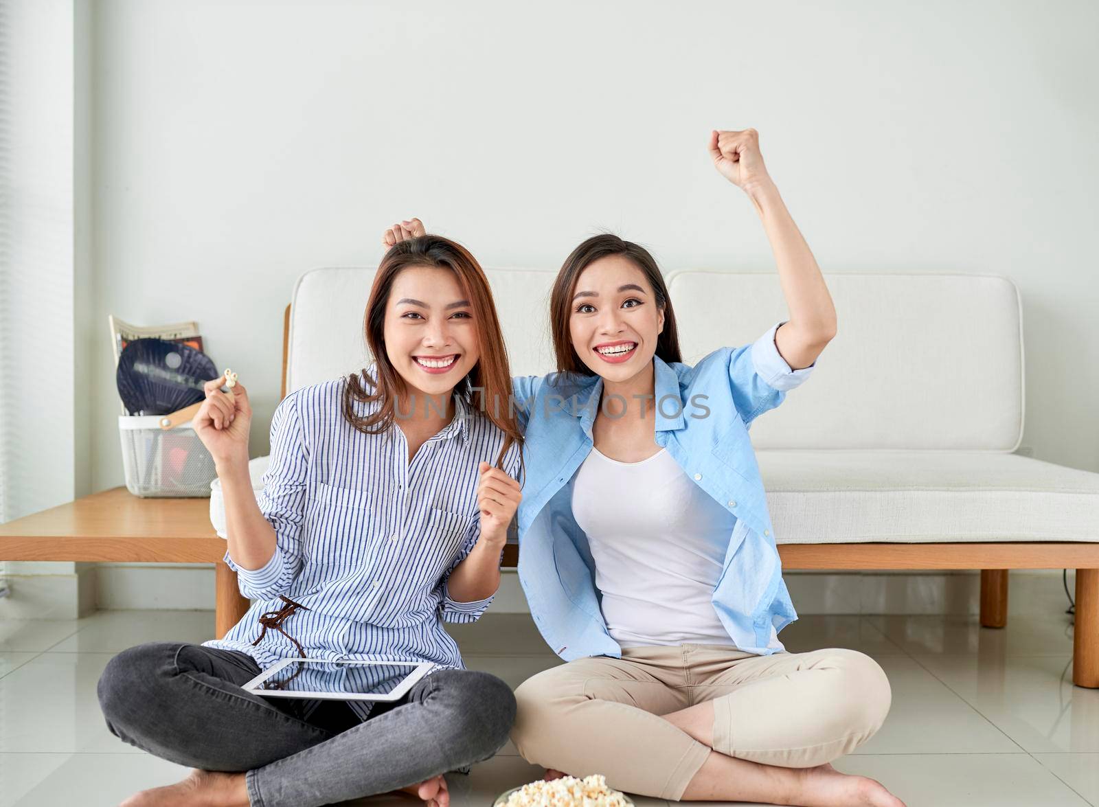 Happy girl friend watching tv at home. by makidotvn