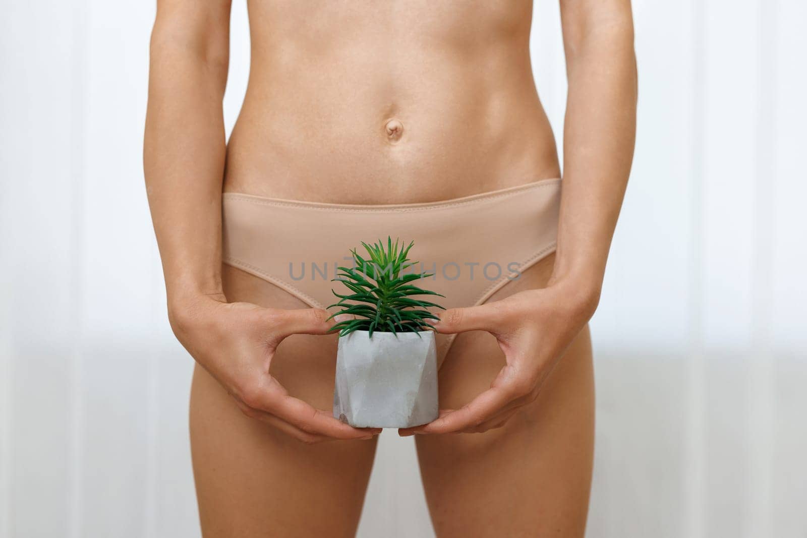 A woman with an cactus in her hands in underwear. The concept of hair removal, smoothness. Concept of depilation and epilation.