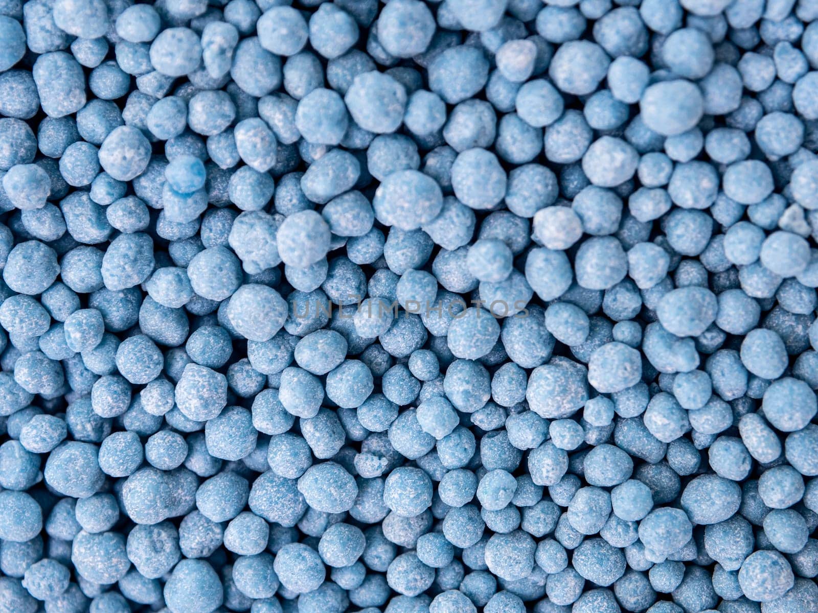Small blue round granules are chemical fertilizers formulated to speed up flowers