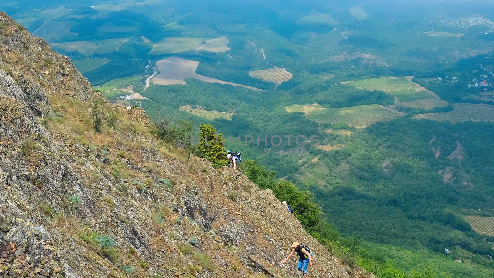 Hike on the peak of rocks mountain. Hiking in the mountains. Tourists with a backpack in mountain panorama by igor010