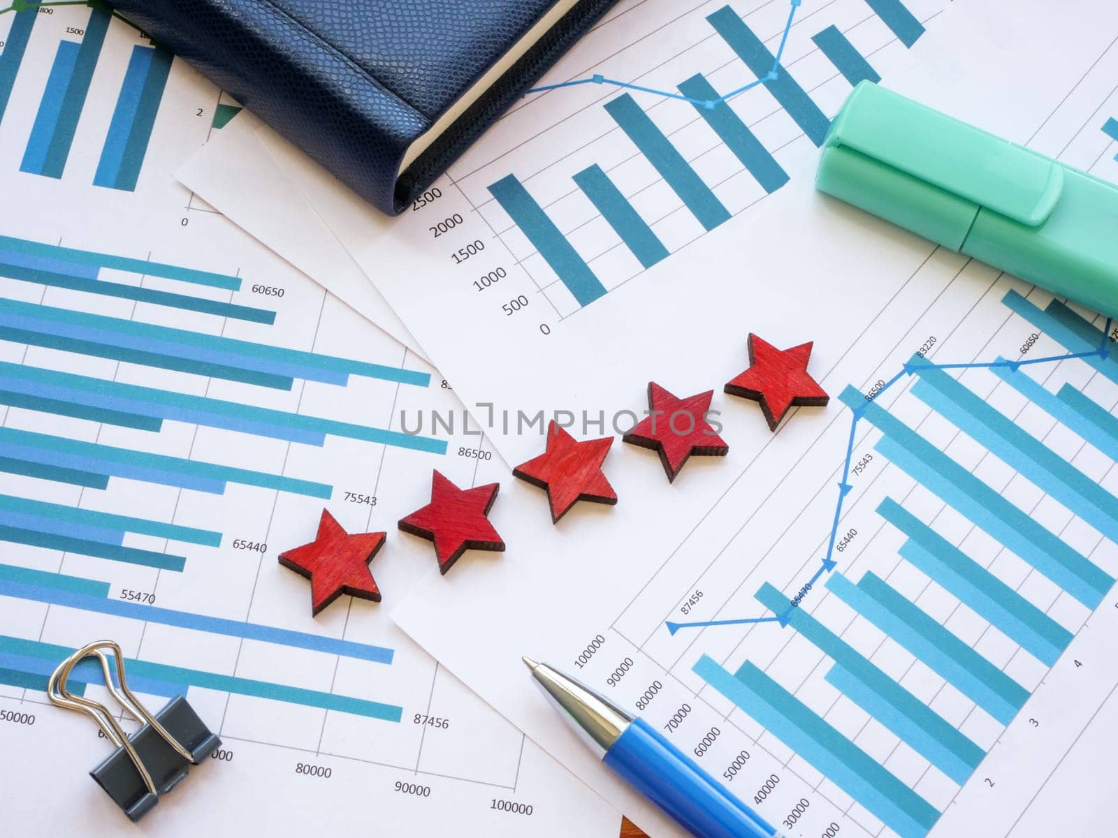 Business graphs and five stars as symbol of high rating on them. by designer491