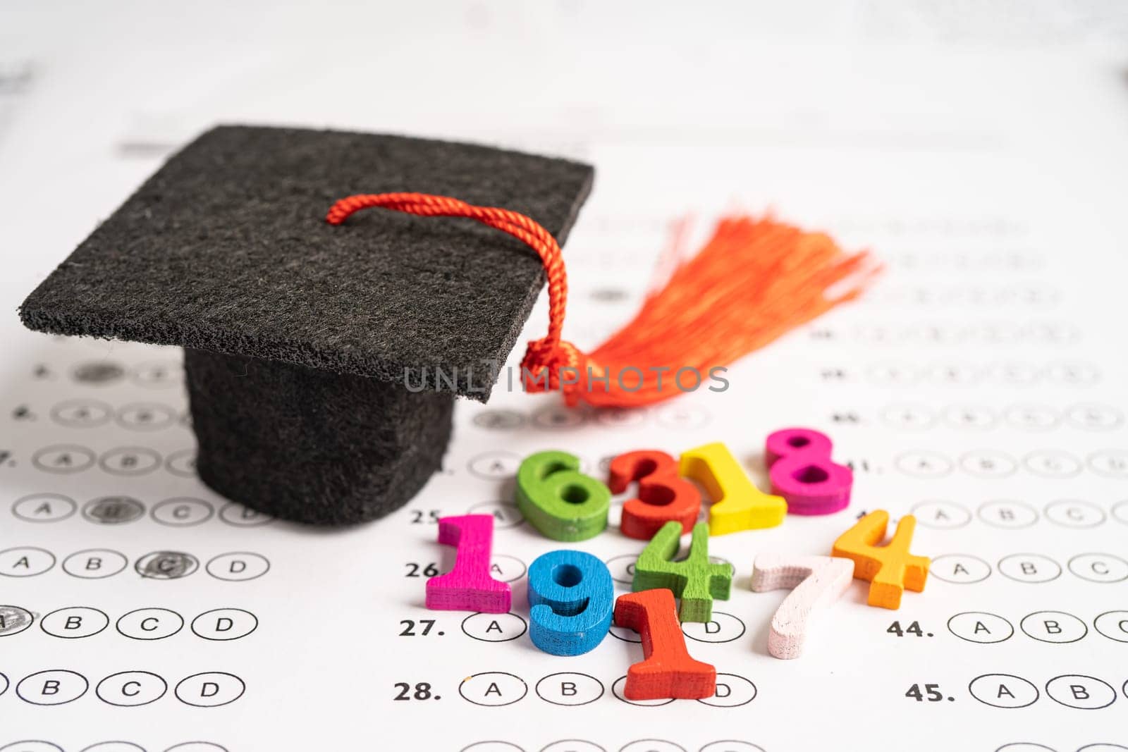 Graduation gap hat and pencil on answer sheet paper, Education study testing learning teach concept.