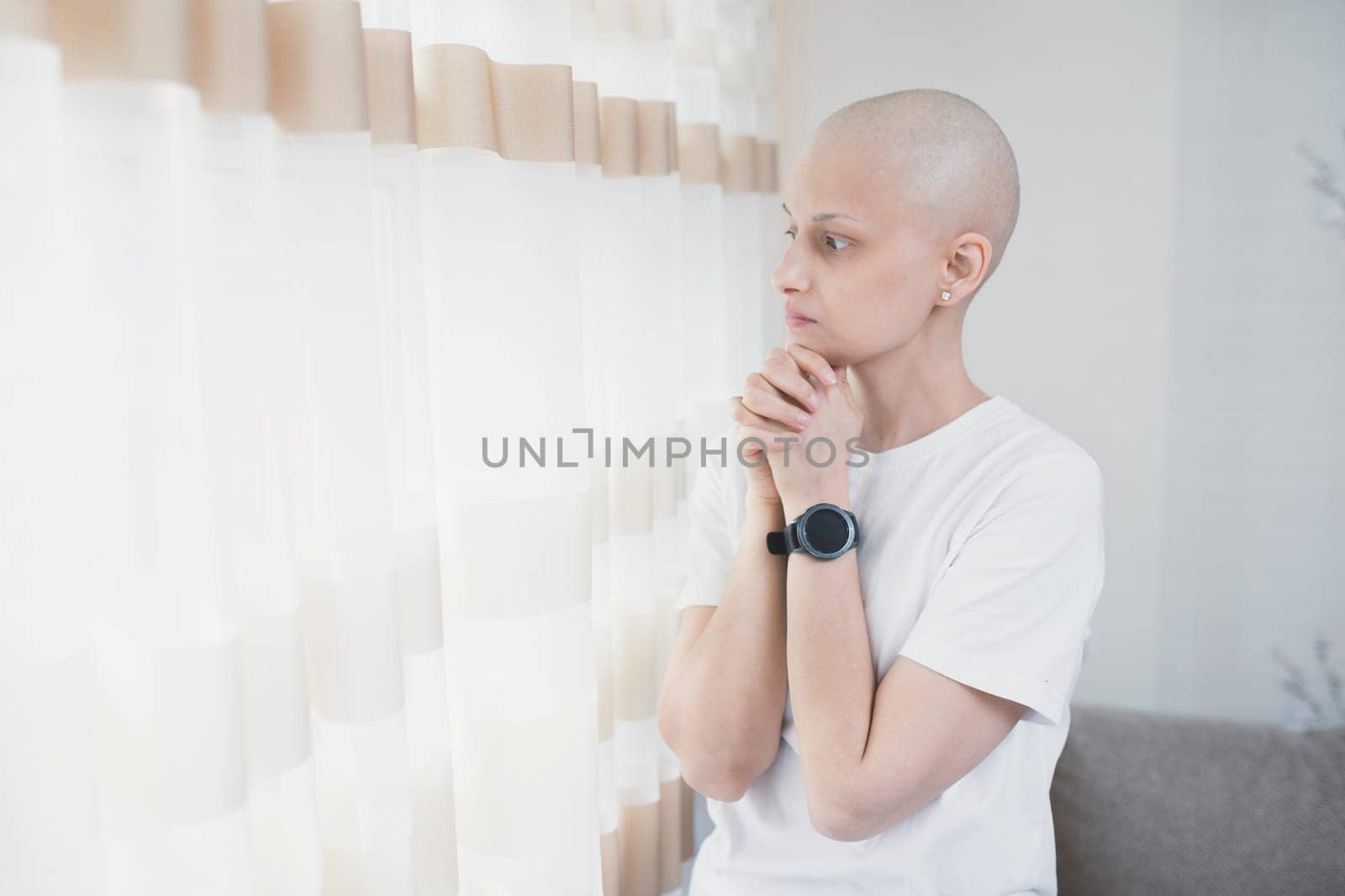 Woman with oncology after chemotherapy praying alone in room by Rom4ek