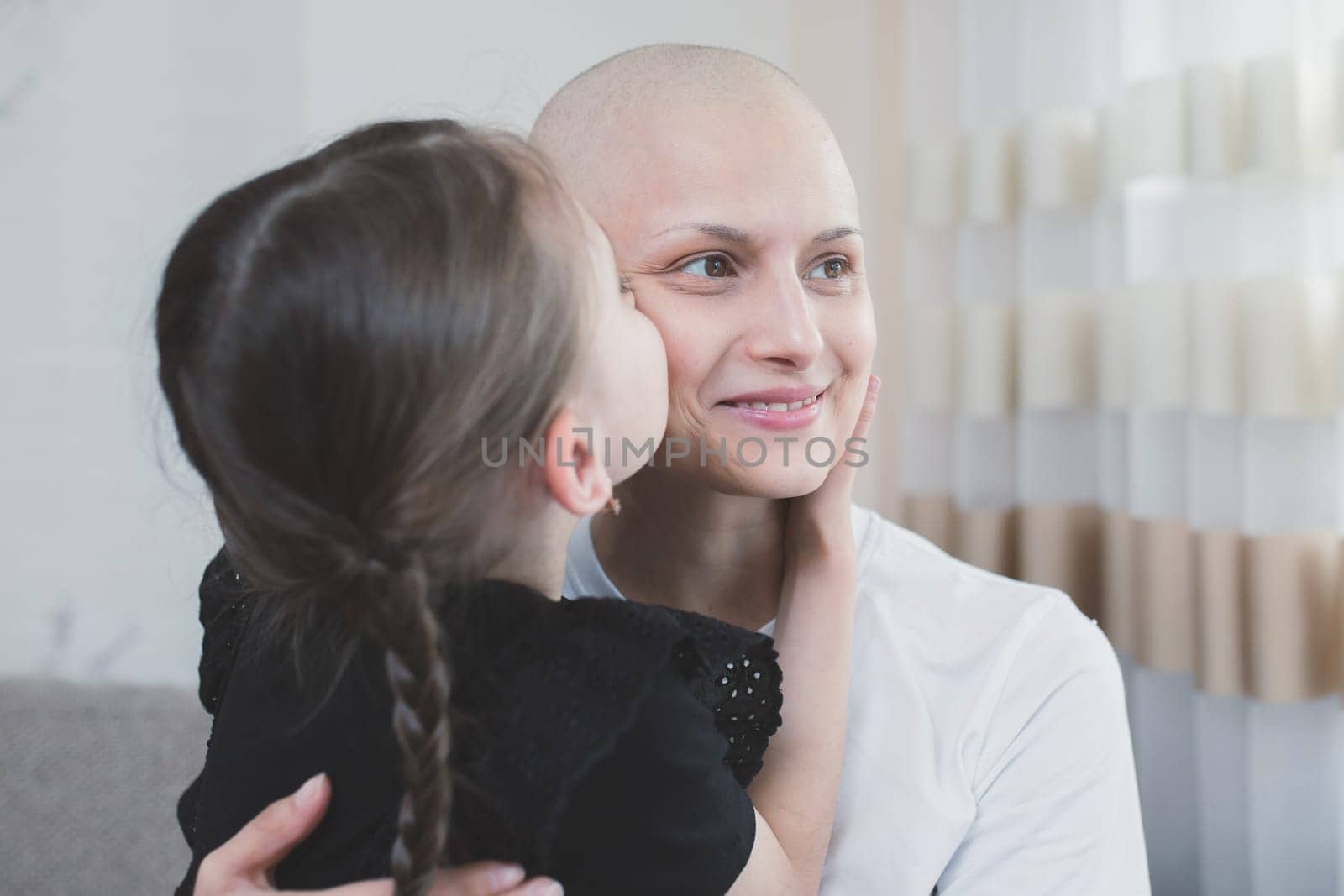Smiling woman with oncology spending time with her child at home. Cancer and family support concept by Rom4ek