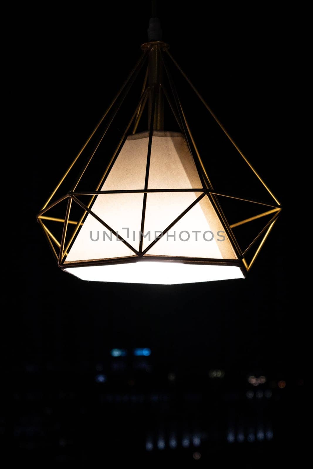 Modern garden pendant lamp hanging outdoor terrace during in the dark, copy space, vertical.