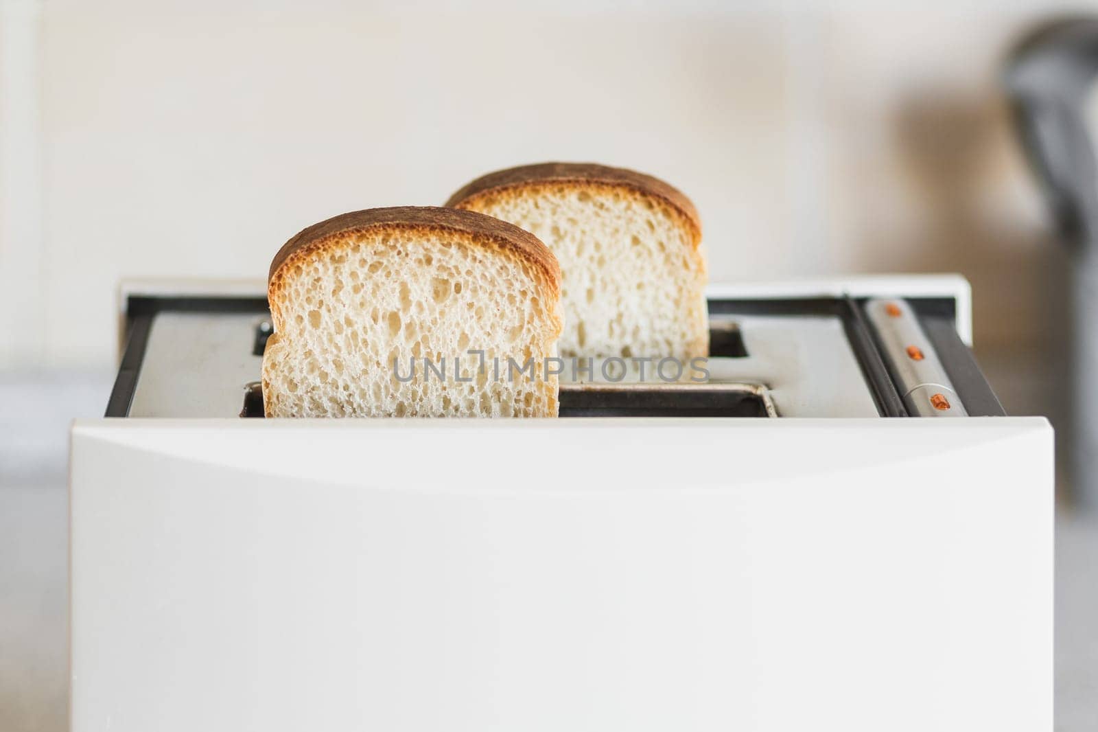 White toaster with white bread in a bright kitchen, selective soft focus, high key by Rom4ek