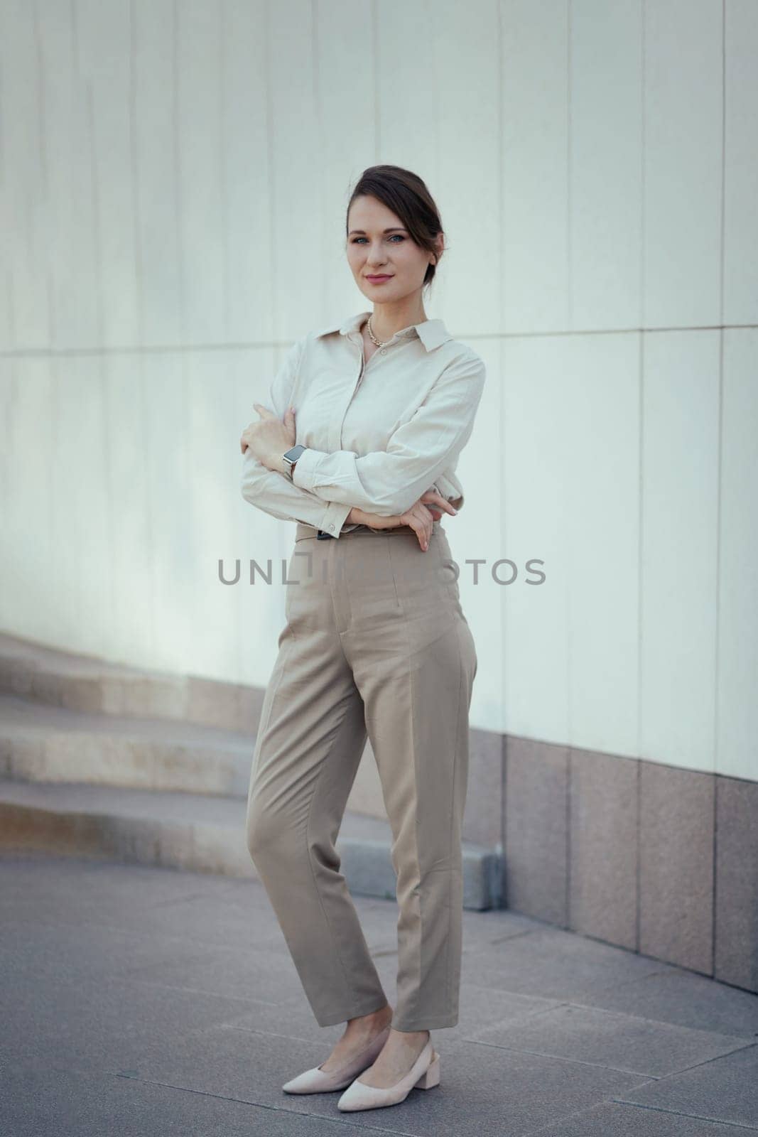 Young caucasian woman in office or business fashion style pantsuit in beige tones.