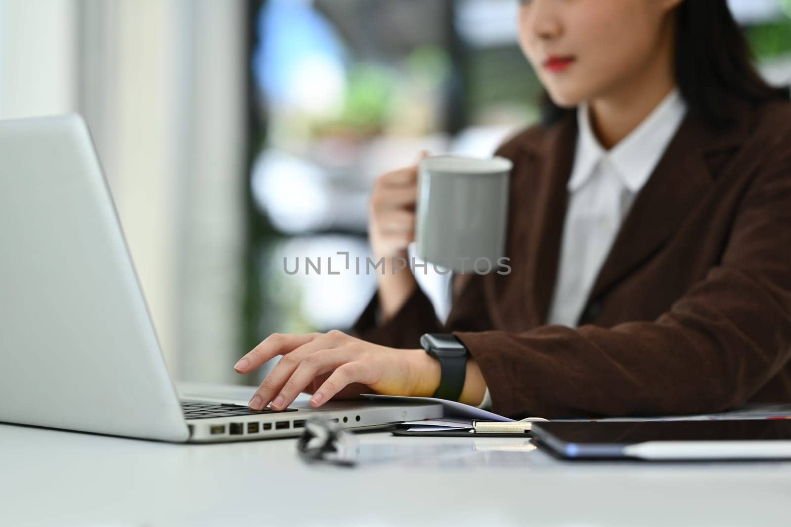Select focused on hand of young businesswoman typing on laptop keyboard. Technology, business and communication.