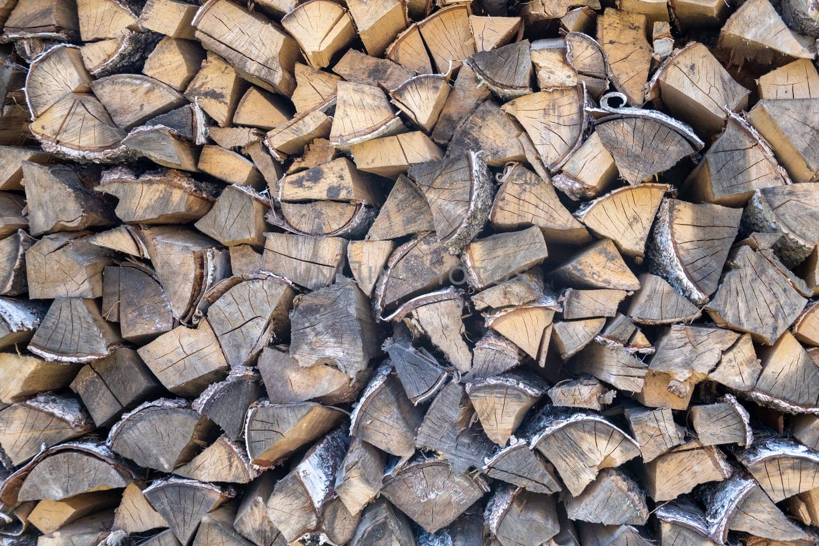 stacked woodpile of birch firewood in nature in the village Close up by AnatoliiFoto