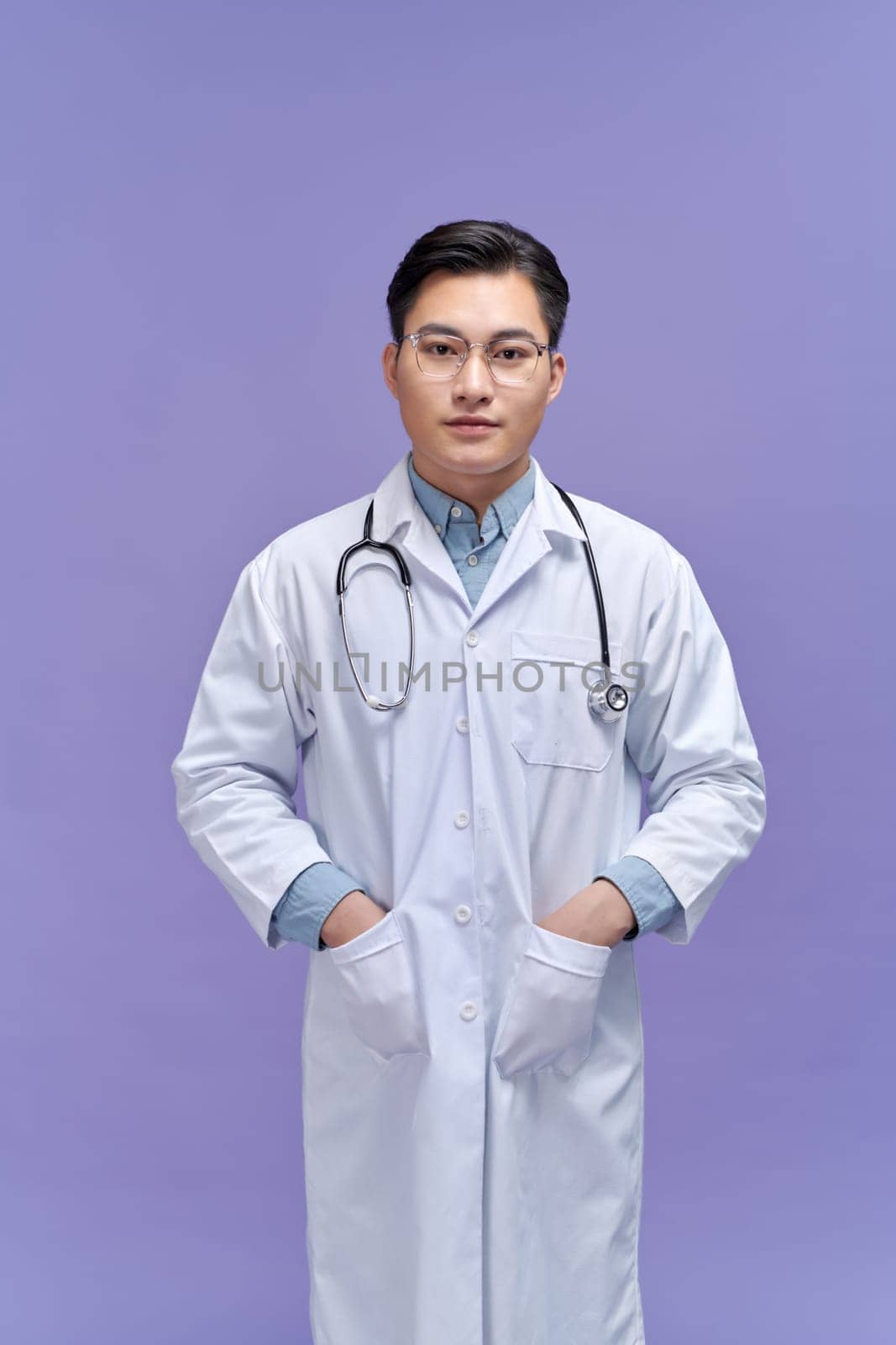 Portrait of cheerful young medical doctor with stethoscope smiling at camera  by makidotvn