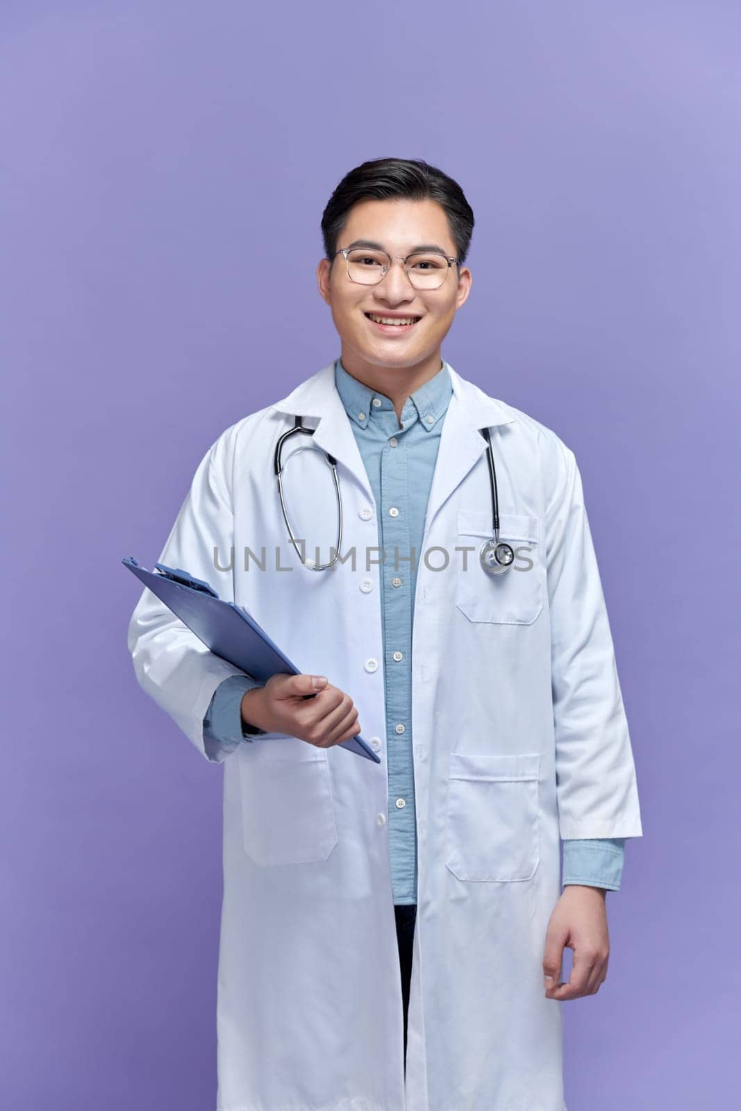 Male doctor standing with folder, isolated on purple background by makidotvn