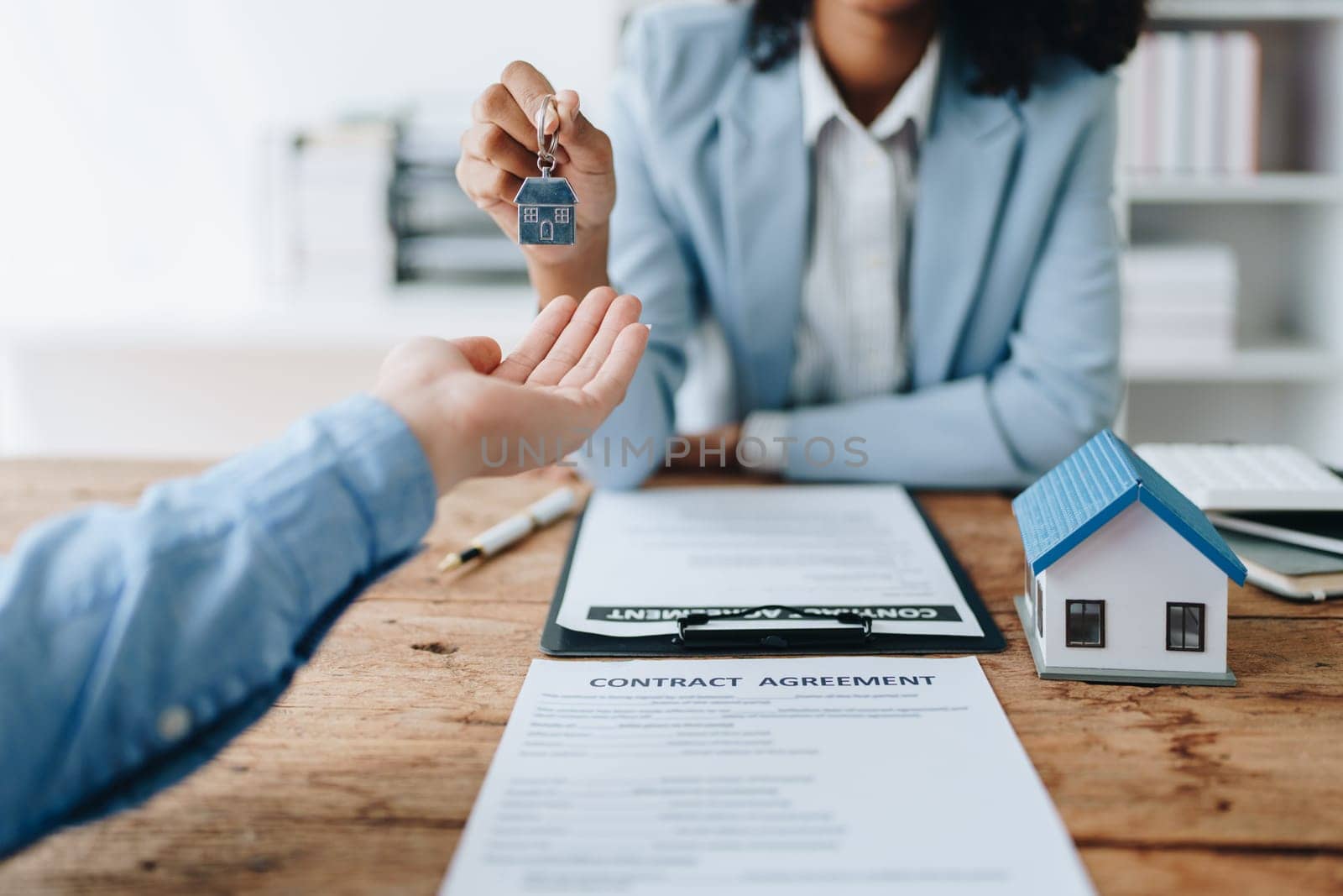 Female African american Real estate company to buy houses and land are delivering keys and houses to customers after agreeing to make a home purchase agreement and make a loan agreement