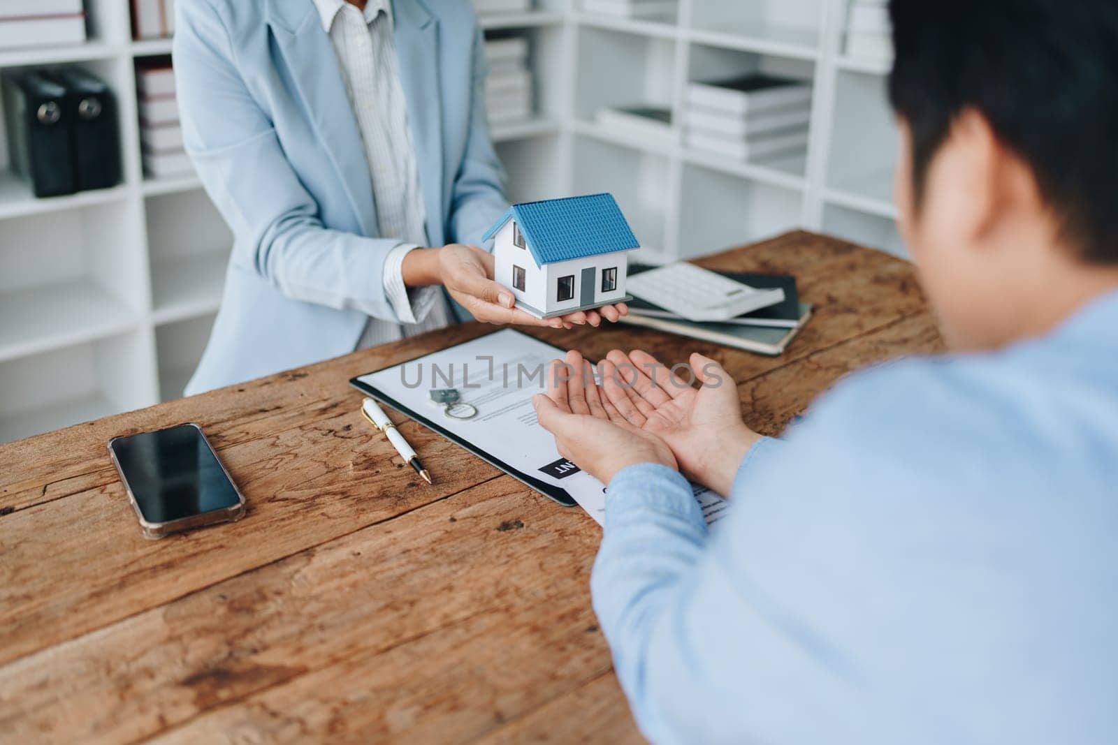 Female African american Real estate company to buy houses and land are delivering keys and houses to customers after agreeing to make a home purchase agreement and make a loan agreement