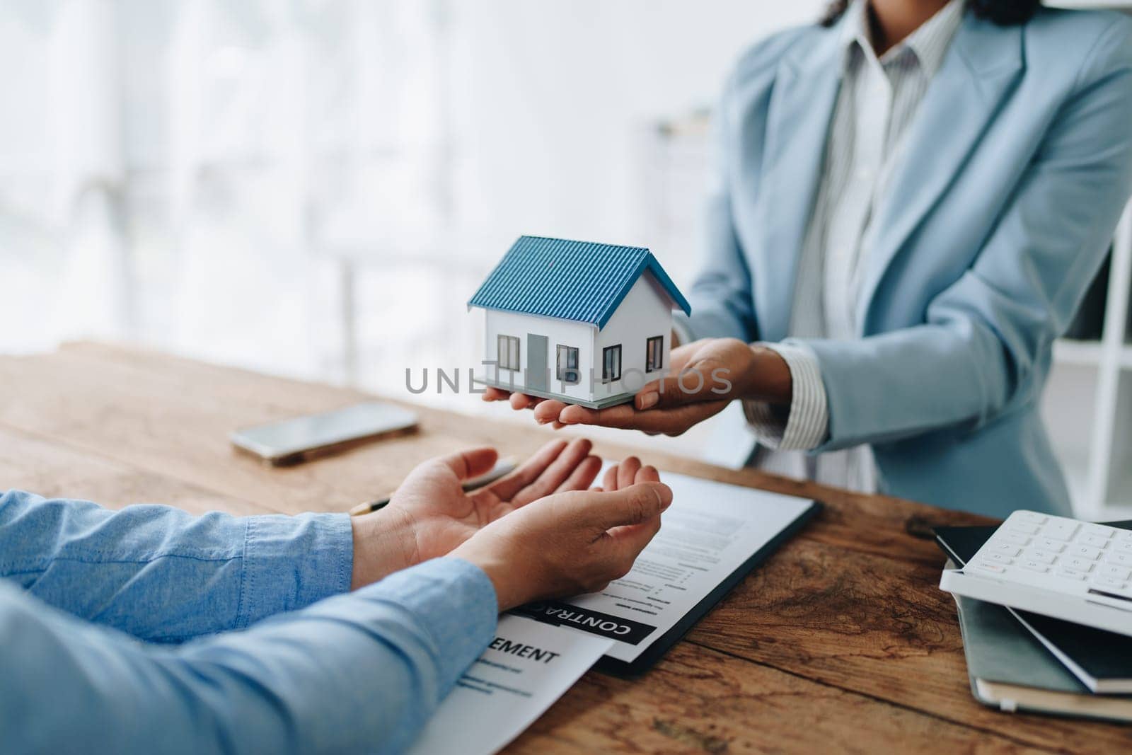 Female African american Real estate company to buy houses and land are delivering keys and houses to customers after agreeing to make a home purchase agreement and make a loan agreement