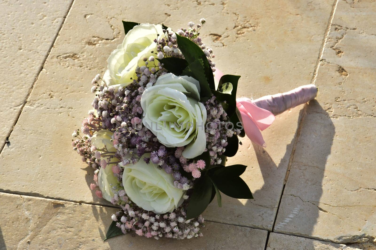 Wedding bridal bouquet of flowers of white roses and small pink flowers with leaves. High quality photo